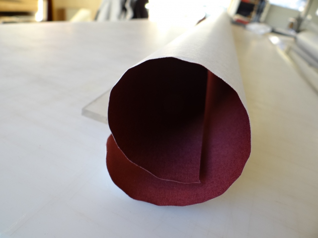 Burgundy book cloth, severely curled from being stored on the roll