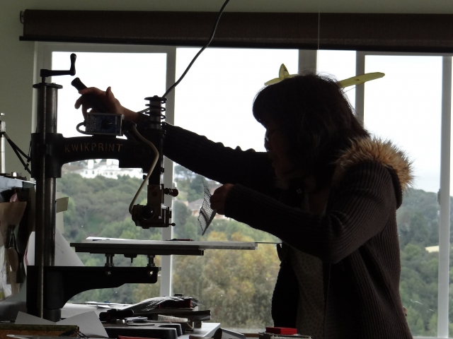 Cindy Lee using the hot stamping press at Dreaming Mind studio on a sunny February afternoon