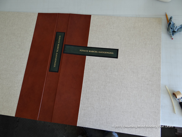 The labels placed in the debossed beds in a cloth and leather portfolio lid