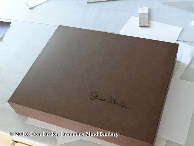The exterior of Oliver Klink's clamshell box showing the brown covering material and black foil stamped signature.