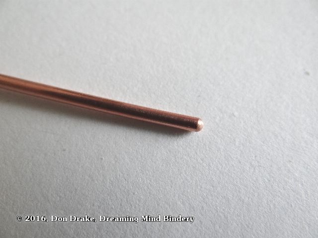 The end of a copper wire after filing and sanding the end round to prevent damage to other materials