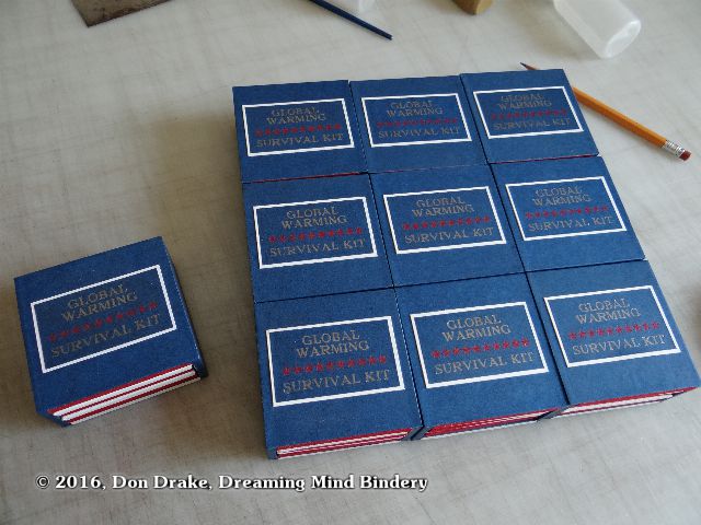 9 copies of Don Drake's miniature book 'Global Warming Survival Kit' arranged in a grid and on artist's proof of the book off to the side