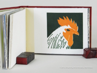 An interior view of Don Drake's binding of the Bay Area Book Artists' (BABA) collaborative project, AlphaBeastiary, showing the 'R' page (rooster). This page was created and printed by Rae Trujillo.