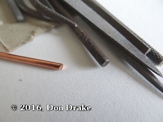 The end of a piece of copper wire showing the sharp end after cutting it to length. Also show are the jewelers files that will be used to take the sharp edges off.